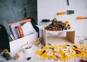 Toy construction set with tools and vehicles on a pegboard for playtime creativity.