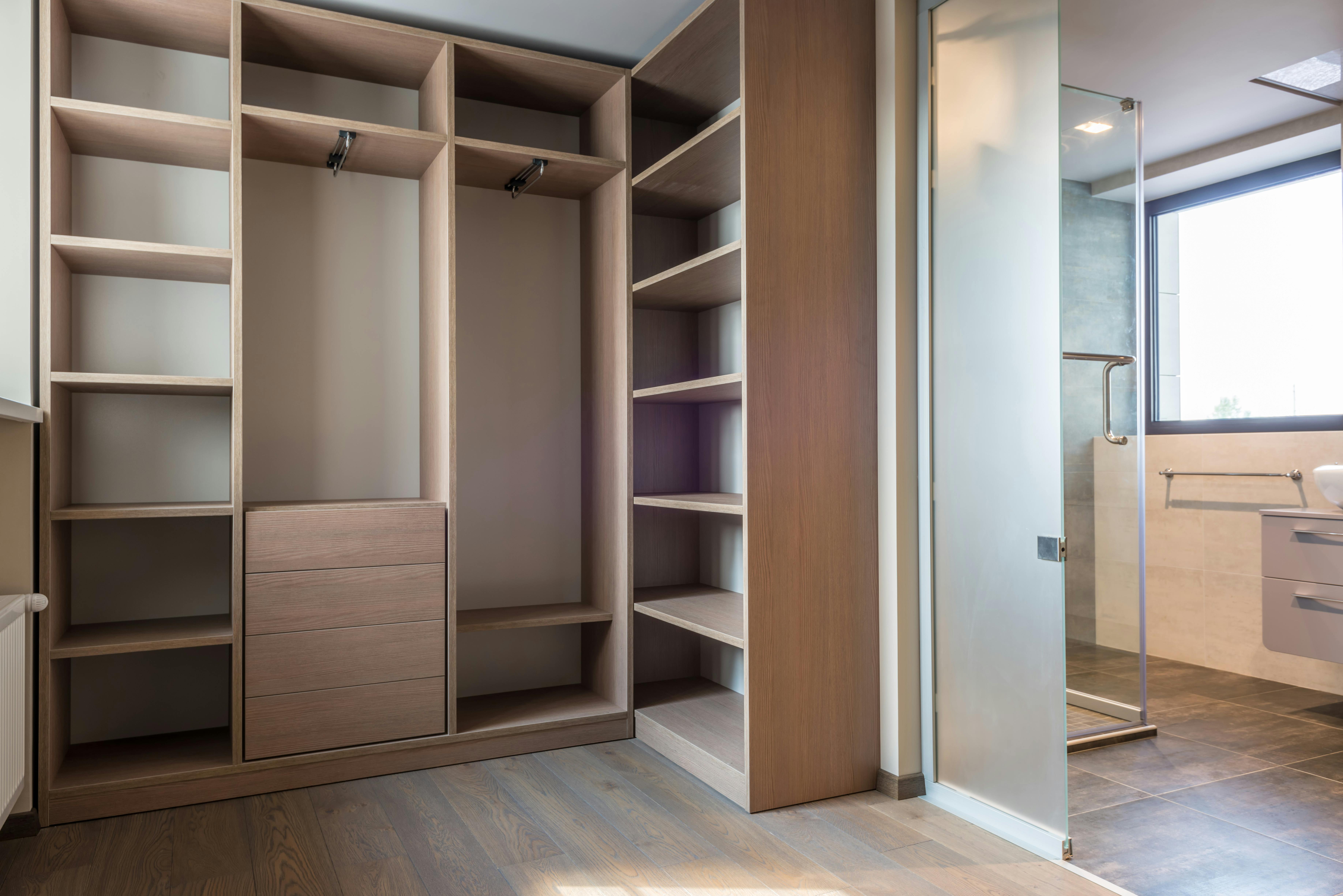 Spacious walk-in closet with wooden shelves and minimalist style.